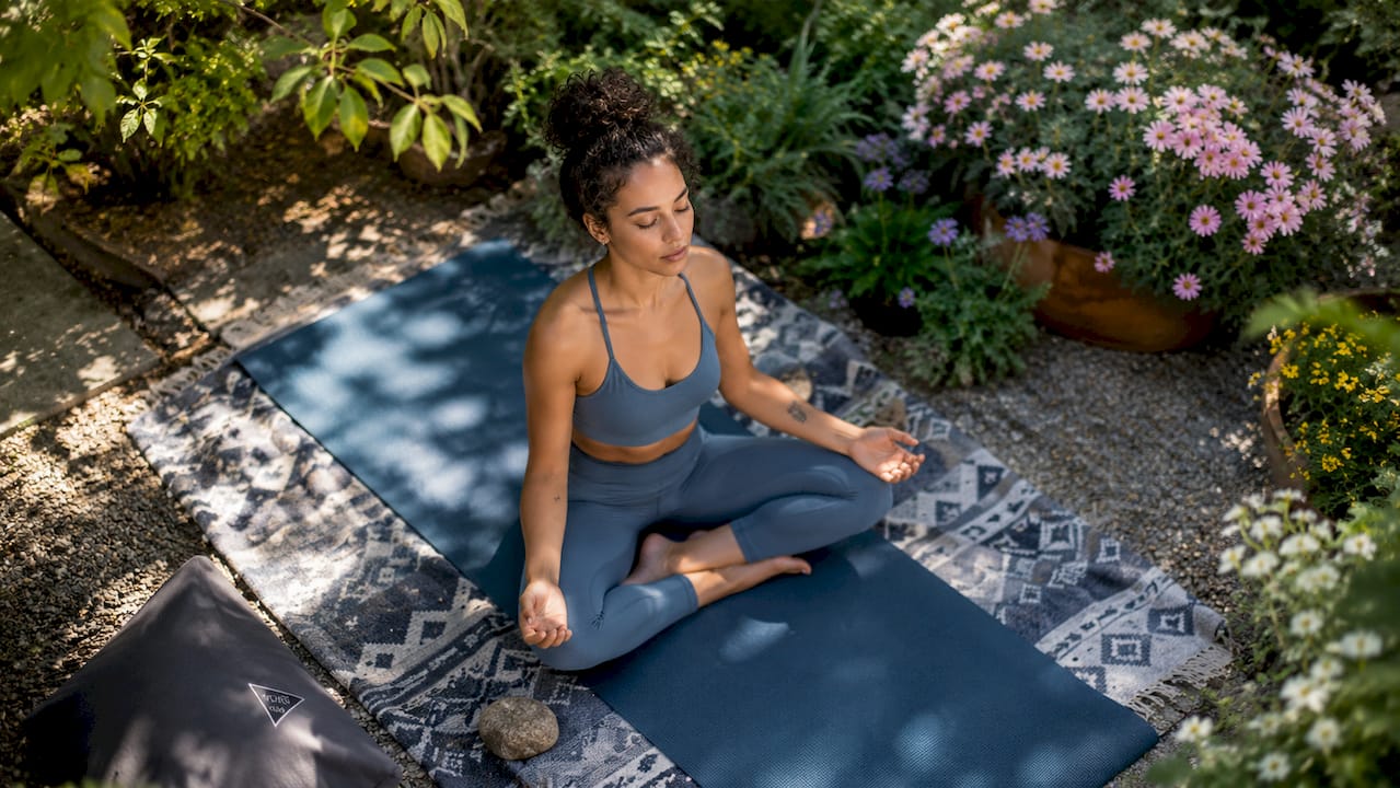 Woman meditating in bright yoga studio